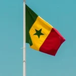 Drapeau sénégalais flottant sur un mât devant un ciel bleu à Dakar