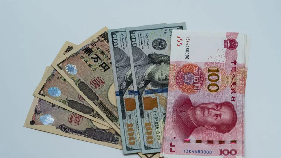 Billets de différentes devises internationales dont des dollars, des yens et des yuans chinois disposés sur une surface