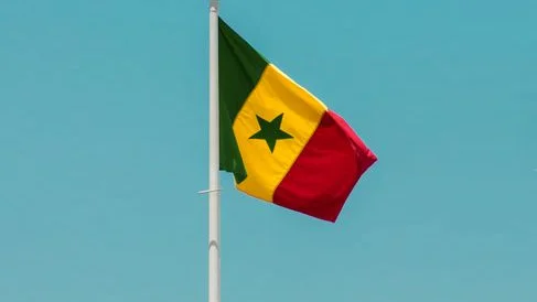Drapeau sénégalais flottant sur un mât devant un ciel bleu à Dakar