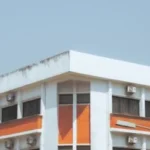 Bâtiment moderne rectangulaire avec parabole satellite sous ciel bleu dégagé