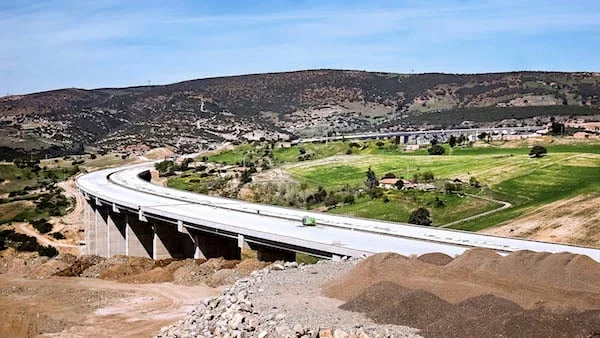 Chantier de construction d'une route autoroutière avec engins de terrassement et bandes de circulation marquées