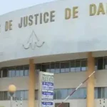 Manifestation politique au Sénégal avec des participants brandissant des drapeaux et pancartes dans un contexte de tensions électorales