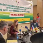 Drapeau russe flottant avec paysage africain en arrière-plan, symbolisant la présence russe en Afrique de l'Ouest