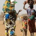 Femmes et enfants déplacés internes au Burkina Faso attendant une aide alimentaire dans un camp de réfugiés